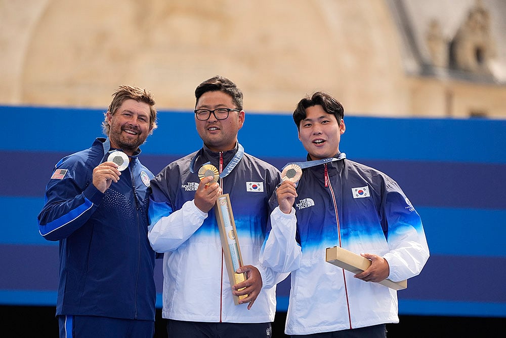 | Photo: AP/Brynn Anderson : Archery men's individual medal ceremony: Gold medalist, South Korea's Kim Woo-jin, center with Brady Ellison and Lee Woo-seok
